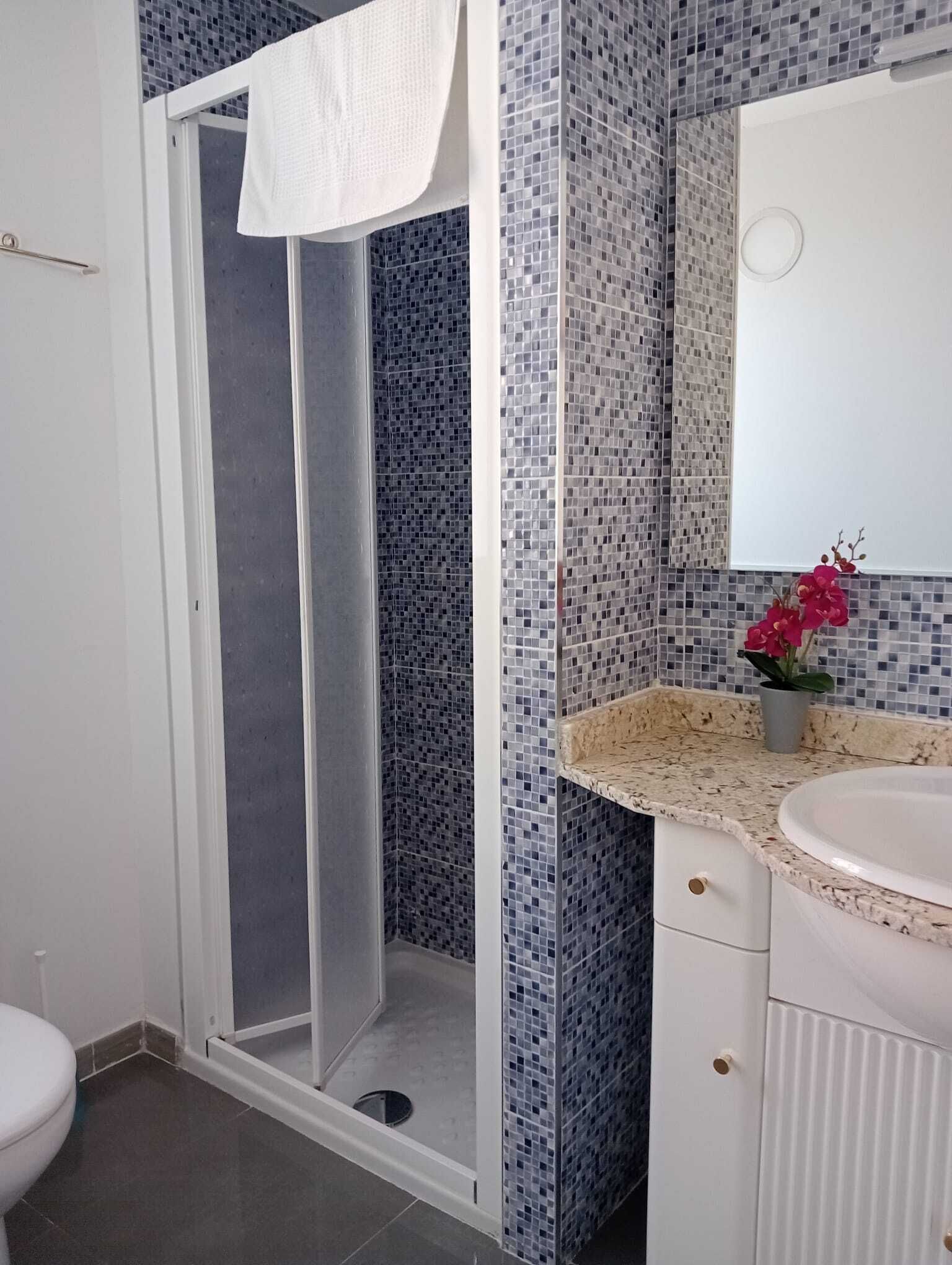 Un baño con ducha, lavamanos e inodoro.