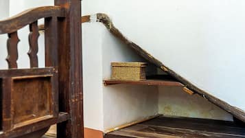 Eine Holztreppe mit einem Korbwägelchen auf der Zwischenebene.