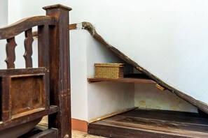 Eine Holztreppe mit einem Korbwägelchen auf der Zwischenebene.