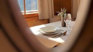 A heart-shaped frame focusing on a dining table with plates, cutlery, and a vase with flowers.