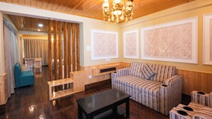 Una sala moderna con techo de madera, un sofá a rayas, una mesa de centro de vidrio y un banco.