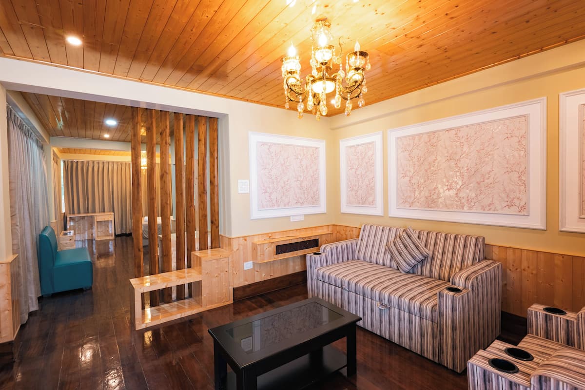 A modern living room with a wooden ceiling, a striped sofa, a glass coffee table, and a bench.