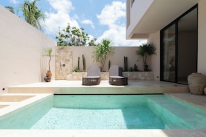 Alberca al aire libre y camastros