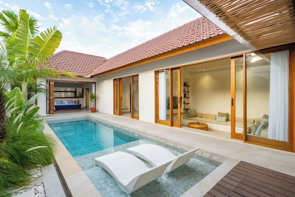 A modern house with a swimming pool, large sliding glass doors, and a cozy interior. - Villa Arkara Seminyak -- 3-bedroom villa, just 10-minutes walk to the beach (Bali)