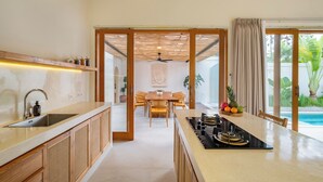 Una cucina moderna con isola centrale, mobili in legno e zona pranzo con tavolo e sedie.