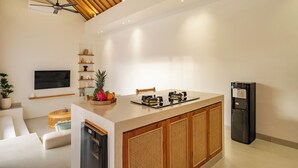 Una cucina moderna con isola centrale, mobili a incasso, frigorifero e ventilatore a soffitto.