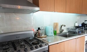 Une cuisine équipée d’une cuisinière à gaz Whirlpool, d’une machine à café et d’un évier.