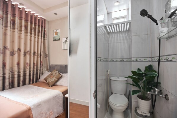 A bedroom with a bed, a shower, and a toilet. - H2T Hotel - Center Bui Vien (Ho Chi Minh City)