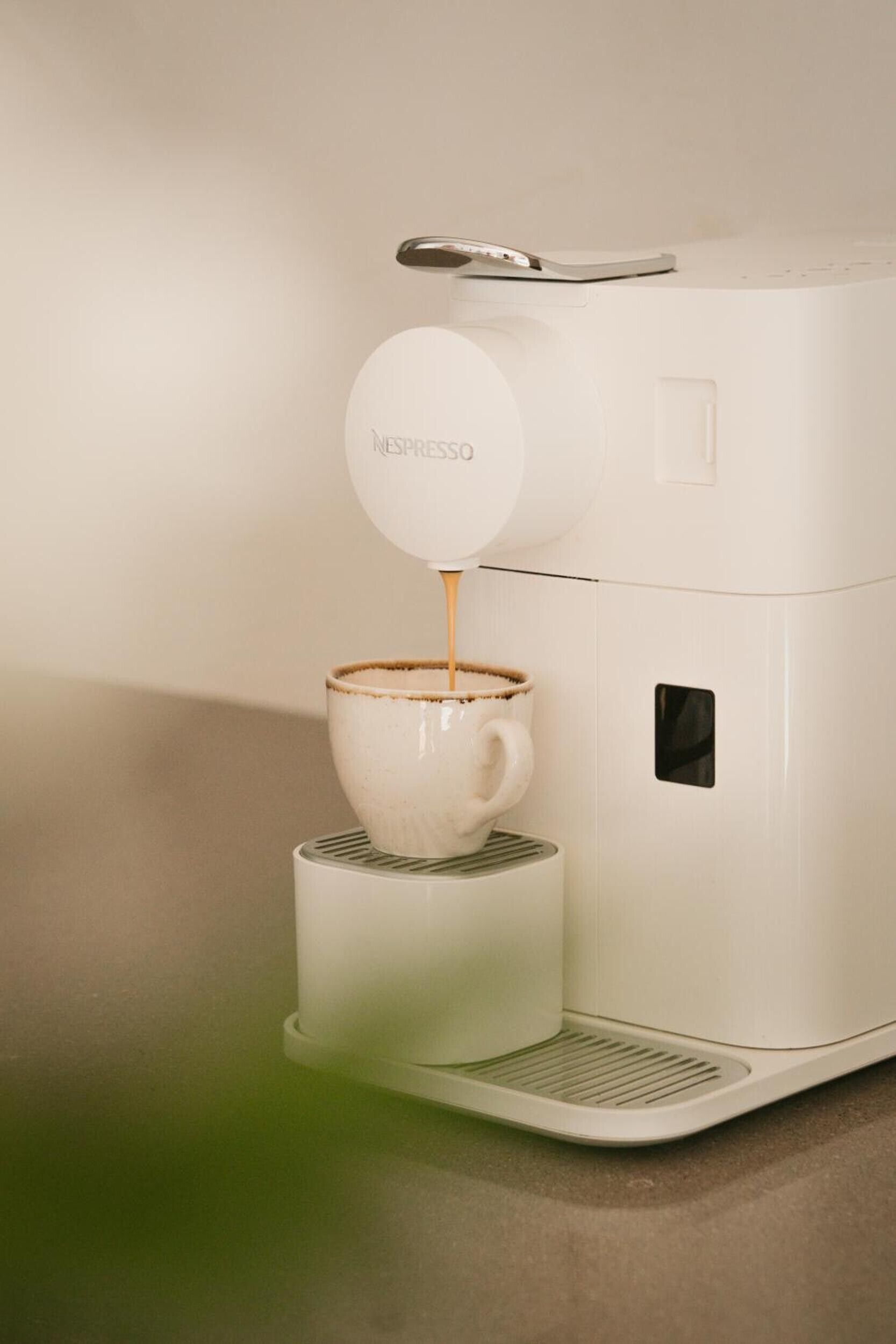 Une machine à café Nespresso verse du café dans une tasse.