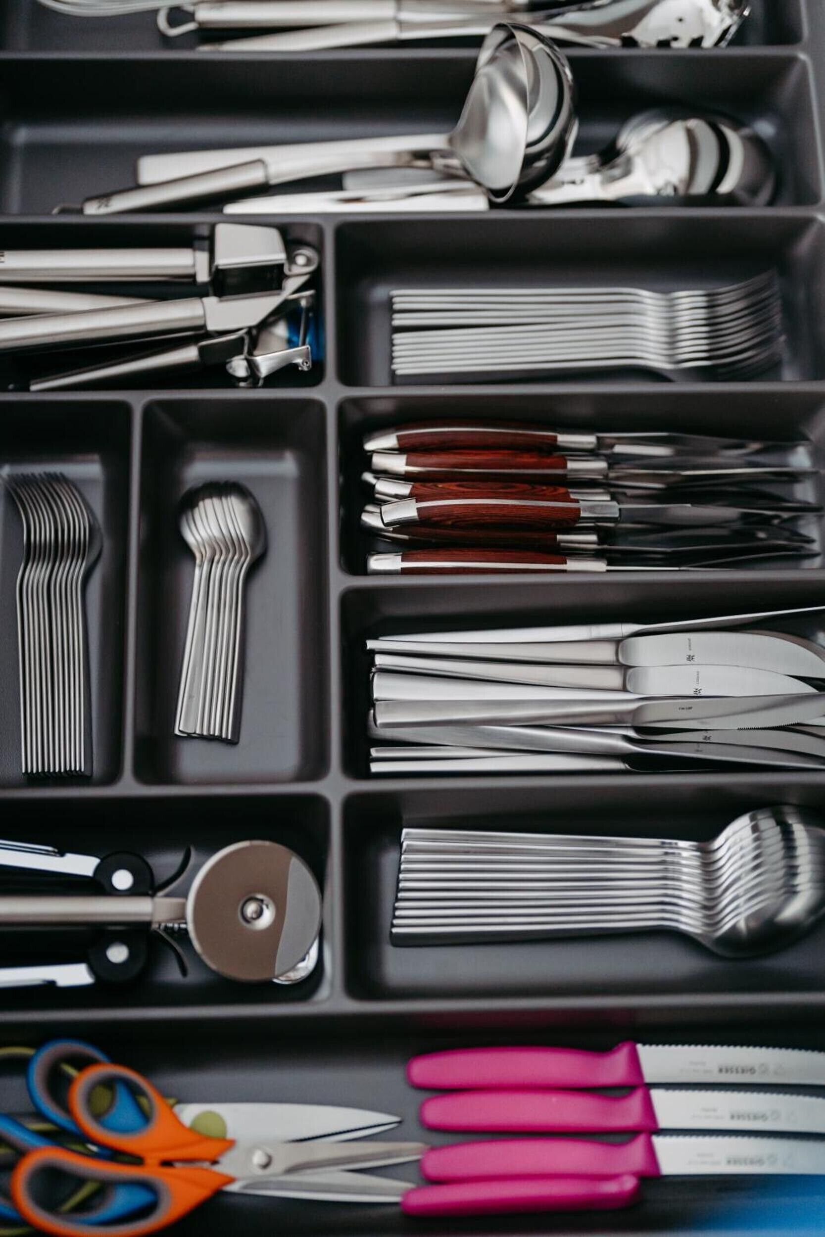 A set of kitchen utensils organized in a drawer.
