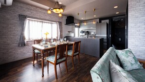 Una cocina moderna con comedor, que presenta una pared de ladrillo, mesa de madera y un sofá.