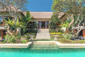 A resort with a pool, a staircase leading to the entrance, and tropical landscaping. - Bougainville Hill Villa (Sukasada)