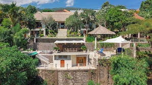 A resort with multiple buildings, outdoor seating areas, and a pool. - Bougainville Hill Villa (Sukasada)