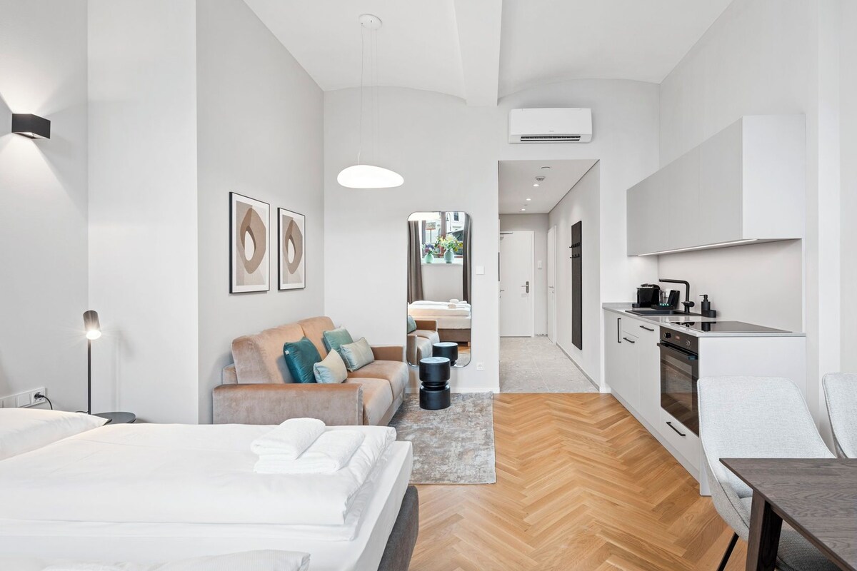 A modern apartment with a kitchenette, a dining area, and a living space.