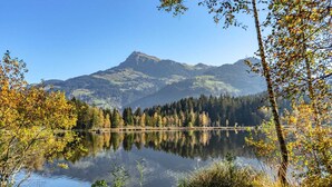 A serene lake with a mountain in the background, surrounded by trees and clear skies. - Apartment in Jochberg with ski-in/out (Jochberg)