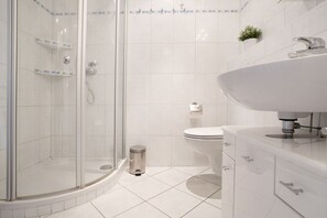 A modern bathroom with a glass shower enclosure, a white sink, and a toilet. - Berolina 314 - Sea whispers - "Sea whispers" with a view of the infinite (Dahme)