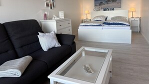 A modern bedroom with a bed, bedside tables, a nightstand, a sofa, and a coffee table. - Berolina 313 - More sea - "More sea" in view... exclusive vacation apartment in the (Dahme)