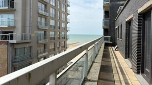 Un immeuble d’appartements moderne doté de balcons donnant sur une plage.