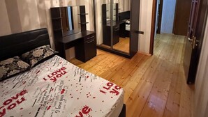 A bedroom with a bed, a dresser, a mirror, and a chandelier. - Sabir bir (Baku)
