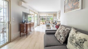 A spacious living room with a sofa, TV, and a dining area with a table and chairs. - Apt with A/C and balcony - 1bdr/4P - Cannes/ beach (Cannes)