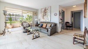 A spacious living room with a sofa, coffee table, and decorative items. - Apt with A/C and balcony - 1bdr/4P - Cannes/ beach (Cannes)