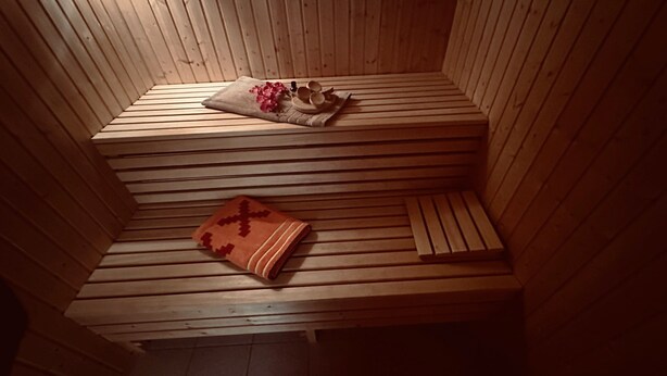 Una sauna de madera con bancos y un banco con una manta.