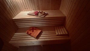 Una sauna de madera con bancos y un banco con una manta.