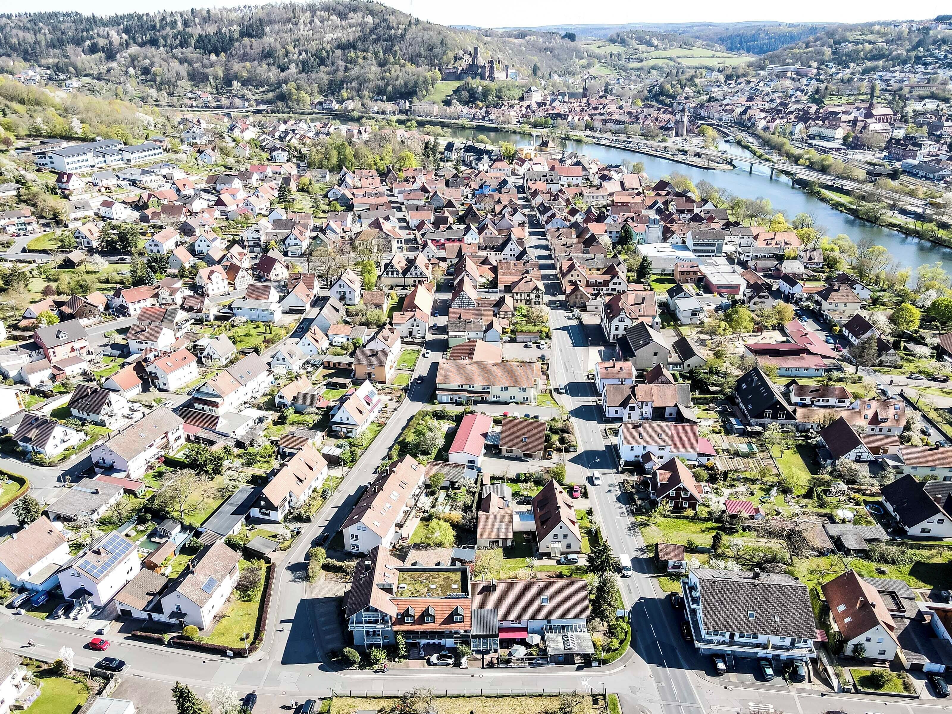 An aerial view of a residential area with houses, roads, and a river.
