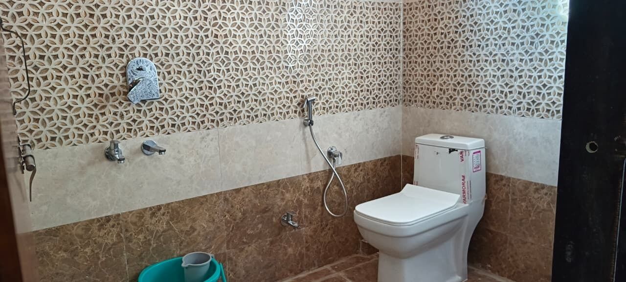 A bathroom with a toilet, a shower, and a sink.