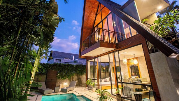 A modern two-story house with a pool, large windows, and a balcony. - Villa Indra Pererenan by Orivista (Canggu)