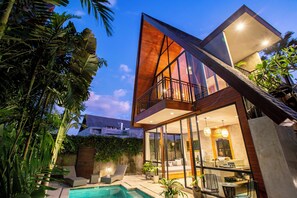 A modern two-story house with a pool, large windows, and a balcony. - Villa Indra Pererenan by Orivista (Canggu)
