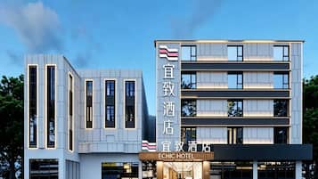 En moderne hotelbygning med et tydeligt skilt, der viser 'ECHIC HOTEL'.