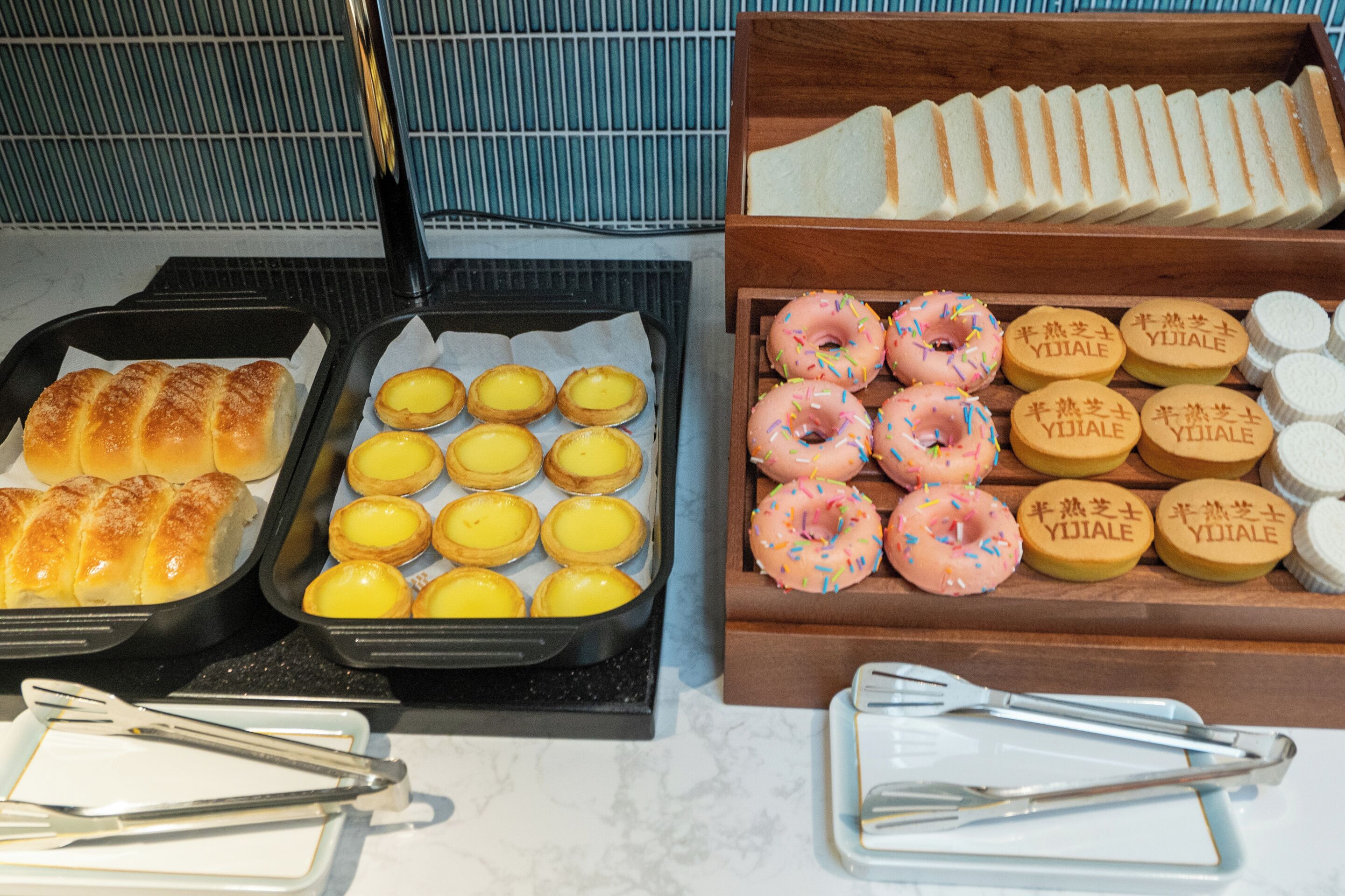 Ein Frühstücksbuffet mit Gebäck, Brot und Donuts.