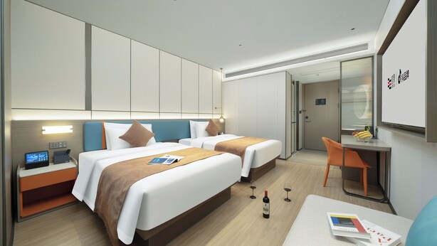 A hotel room with two beds, a desk, a chair, a nightstand, and a minibar. - YiZhi HotelShangxiajiu Pedestrian Stree (Guangzhou)