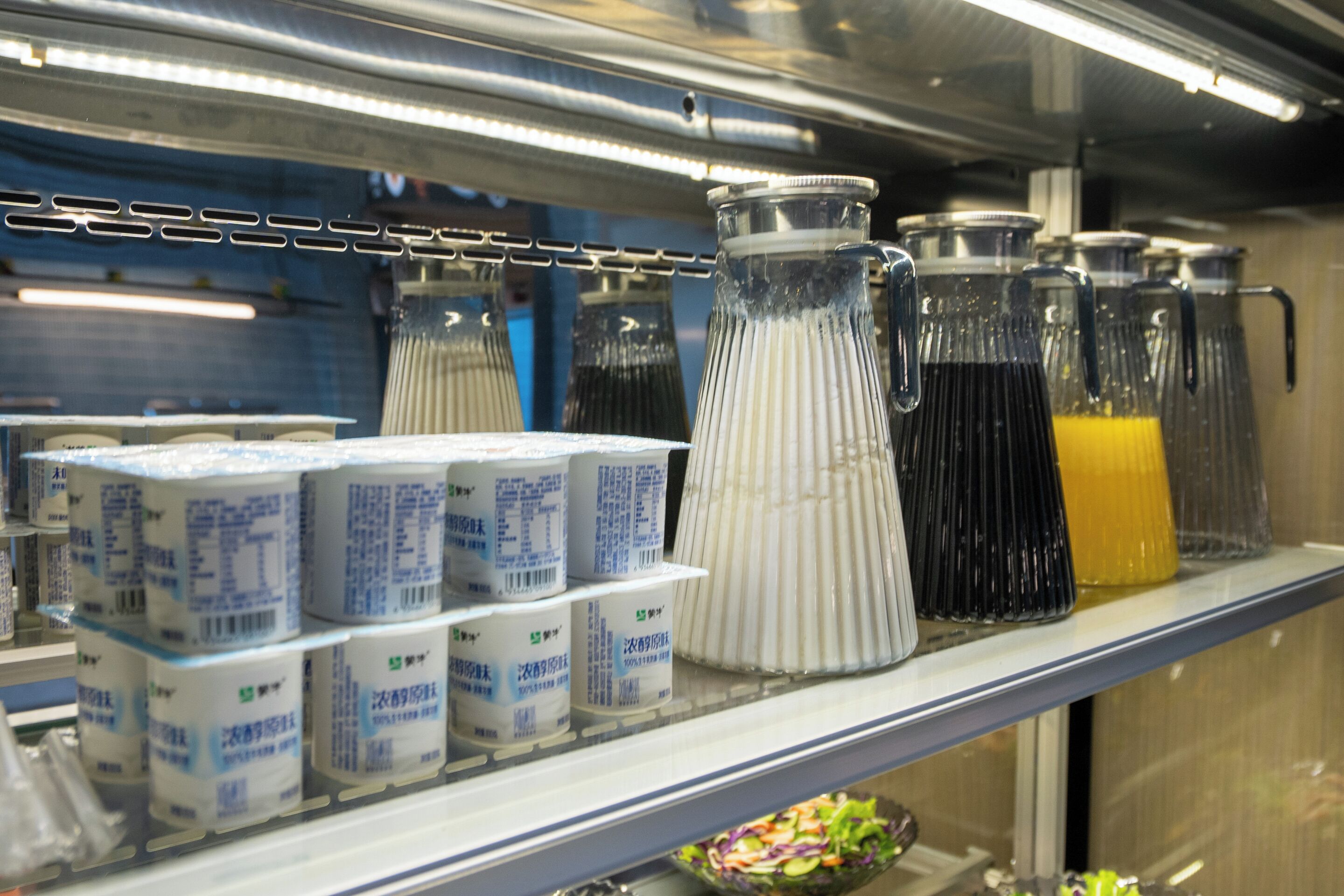 A refrigerated display with bottled beverages and packaged goods.