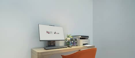 A modern office space with a desk, computer, keyboard, mouse, and a chair.