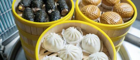 Three bamboo steamers with different types of dumplings.