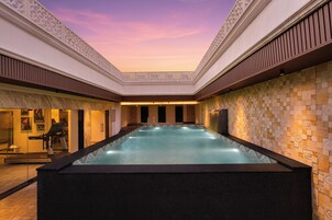 Un jacuzzi con pared de azulejos y techo con diseño decorativo.