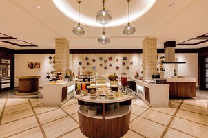 Una cocina moderna con una isla central, iluminación colgante y un salpicadero decorativo.