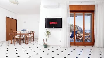 Apartamento Confort, balcón, vistas parciales al mar | Zona de estar | Smart TV de 40 pulgadas con canales digitales