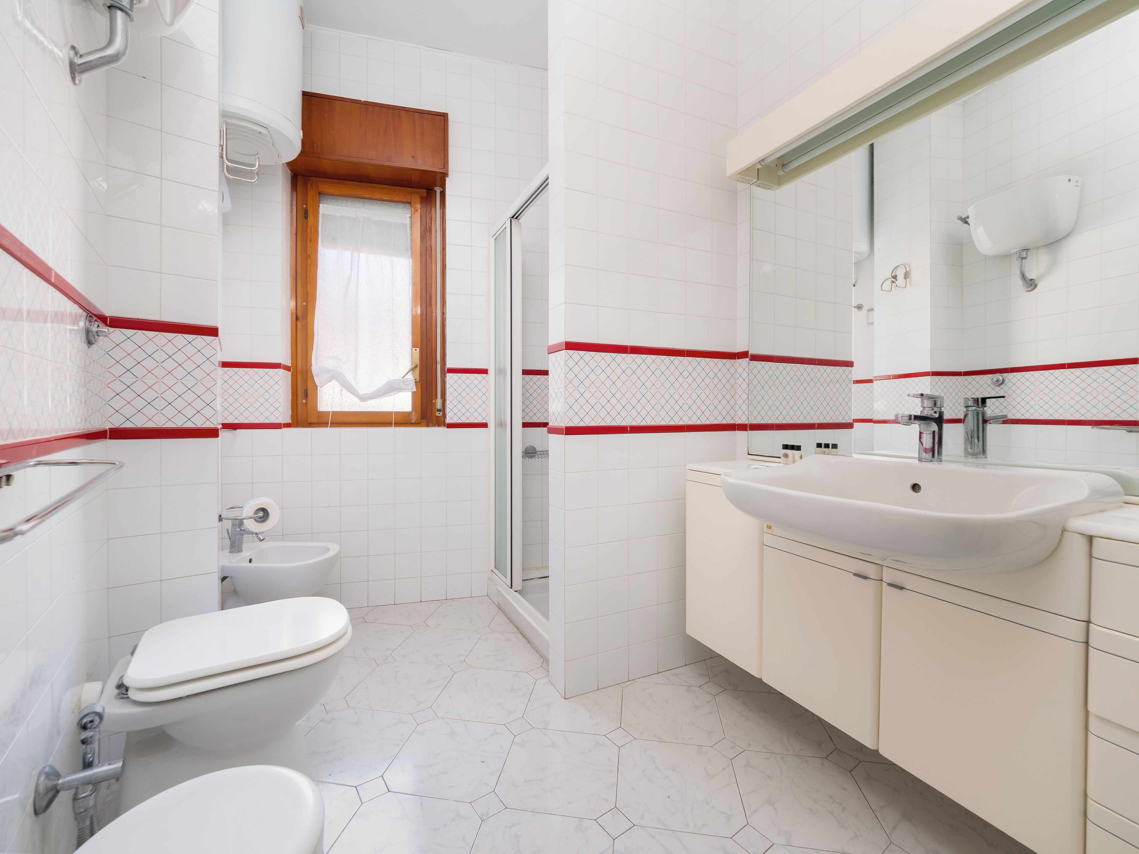 A bathroom with a toilet, sink, and shower.