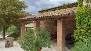 A rustic stone building with a tiled roof, a wooden bench, and a potted plant in the foreground. - Agriturismo Alla Vecchia Quercia vacation apartment "Cagli" for 2 persons (Pergola (PU))