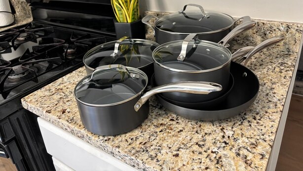 A kitchen with granite countertops, a stove, and four pots with lids. - Stockbridge Home w/ Master Suite on the Main (Stockbridge)
