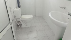 A bathroom with a toilet, sink, and tiled floor.