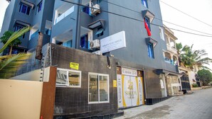 A modern building with multiple balconies, a sign for 'Suroon Villas Suites', and a storefront named 'Cuisine 254'. - Sukoon Nyali Suites (Mombasa)