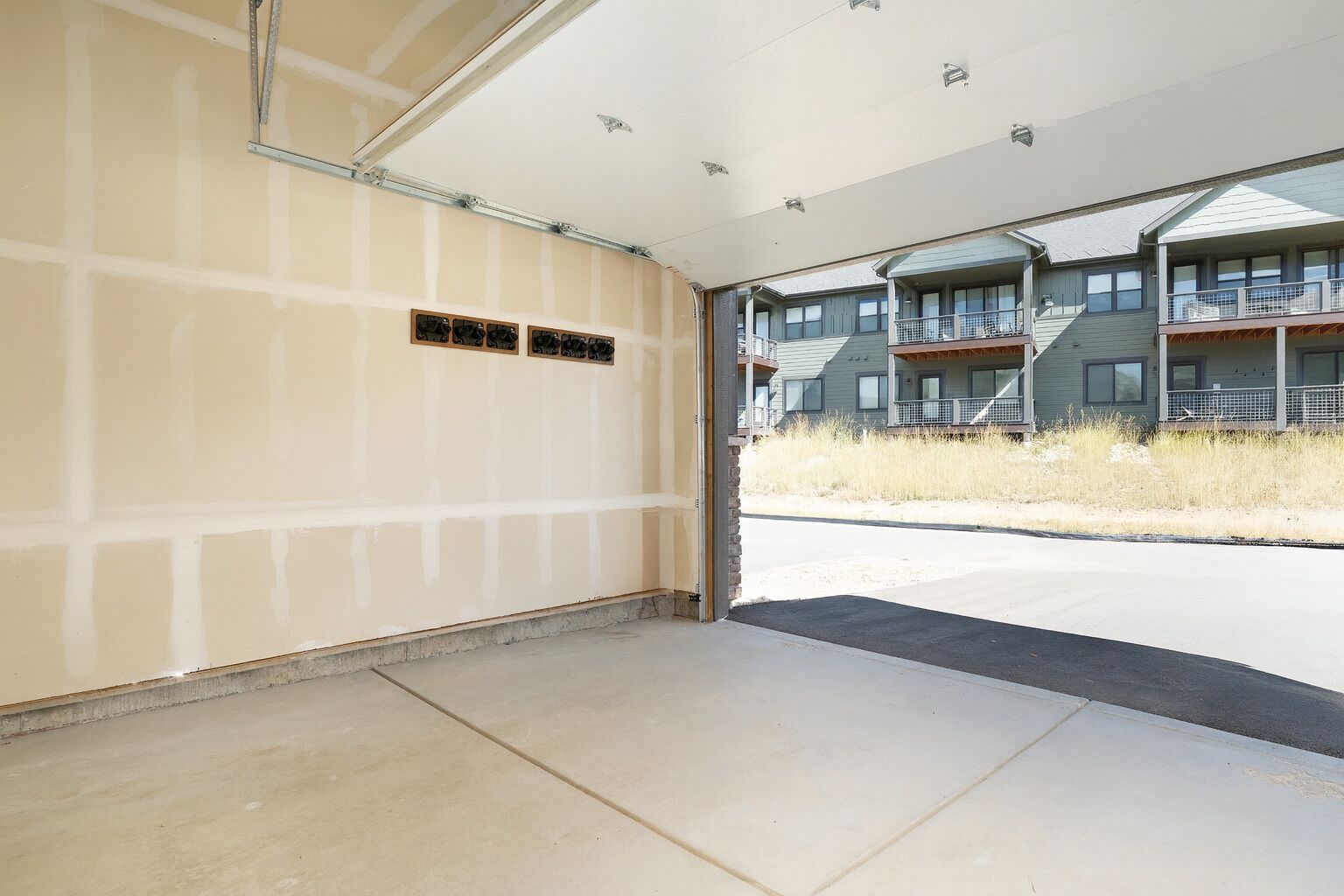 A garage with a concrete floor and a partially finished wall.