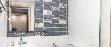 A bathroom with a white sink, a toilet, and a shower enclosure.