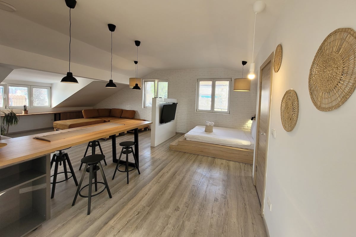 Een moderne keuken met een houten kookeiland, barstoelen en hanglampen.