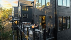 A modern two-story house with large windows and a deck area. - Sevierville Retreat • Indoor Pool + Hot Tub + Firepit + Gym | Ridgeview Retreat (Sevierville)