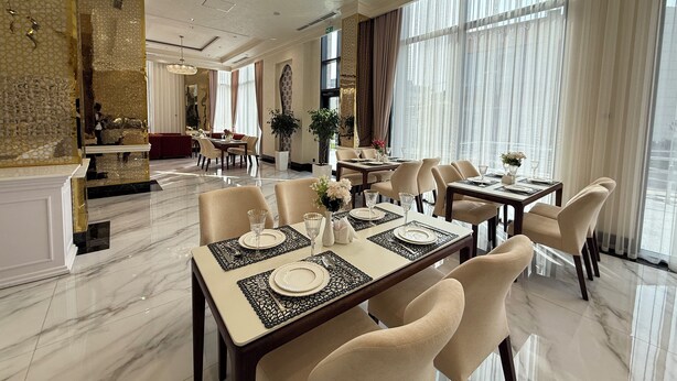 A spacious dining area with marble flooring, elegant table settings, and large windows with sheer curtains. - Khorazm Hotel (Tashkent)